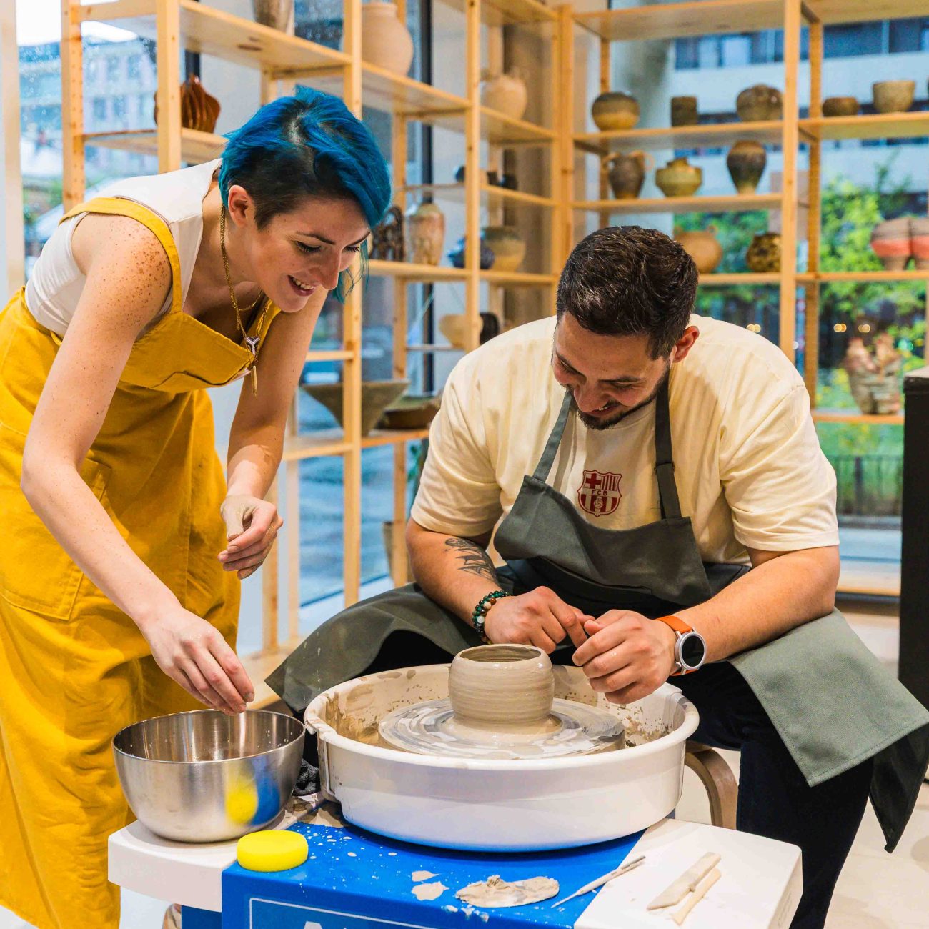 A man and a ceramic teacher during pottery making workshop on the pottery wheel at Zolta Studio