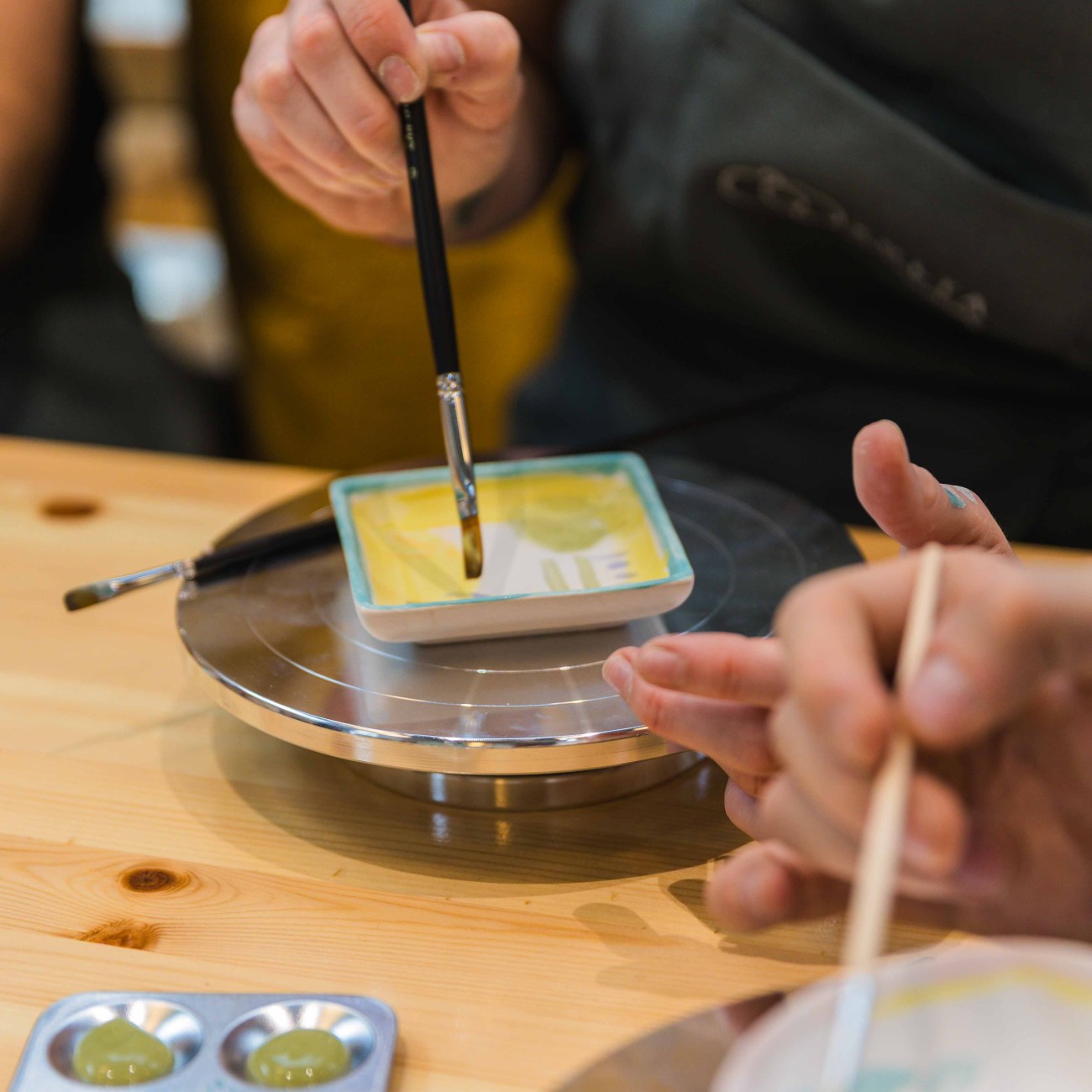 A close up shot of an artist painting on ceramic at zolta ceramic studio Vienna Team Building: Ceramic Painting