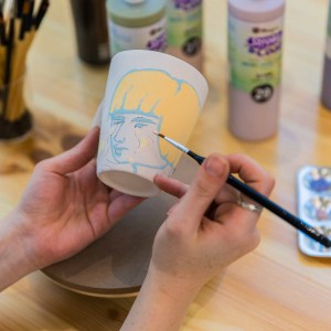 Ceramic painting of a mug with a girl with yellow hair at Zolta Ceramics Studio, Vienna