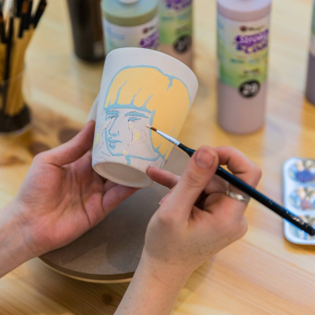 Ceramic painting of a mug with a girl with yellow hair at Zolta Ceramics Studio, Vienna