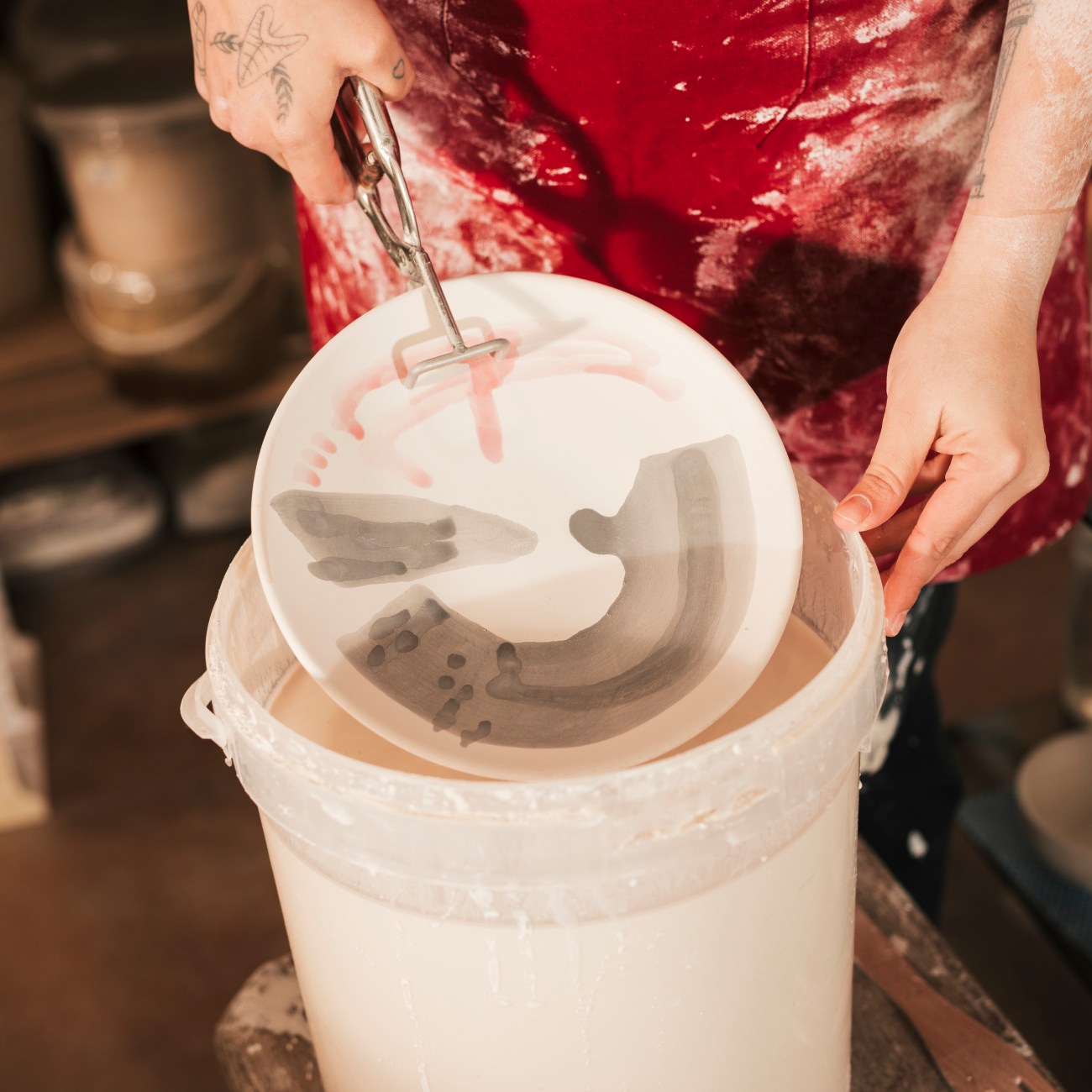 female-craftswoman-painting-ceramic-dish-with-paint-workshop keramik glasur workshop