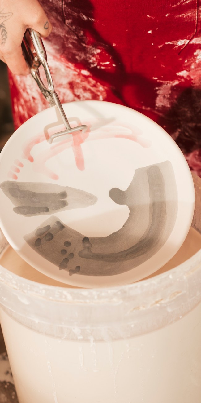 female-craftswoman-painting-ceramic-dish-with-paint-workshop keramik glasur workshop