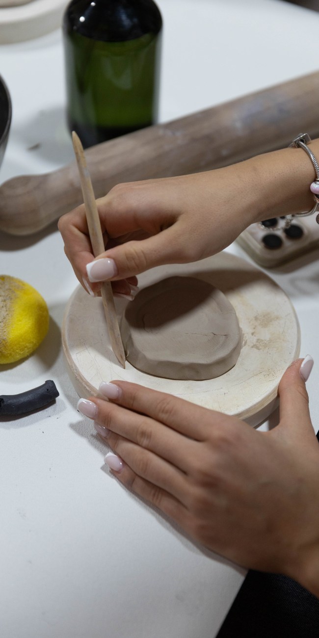 a lady making a ceramic plate using a round clay in Zolta ceramics studio Vienna