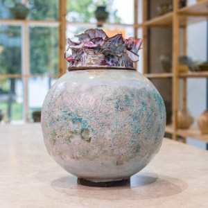 Stoneware sculpture Flower Bomb by Sirin AlMasri at Zolta Ceramics Studio Vienna — round vessel with textured turquoise-beige body and red petal-like glazed crown.